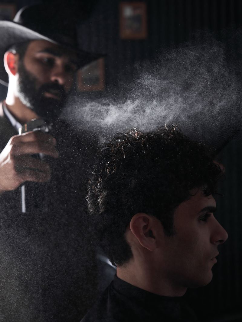 Barber misting a client's curls